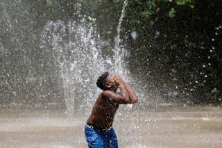 Child in Louisville, Kentucky, spray water on his face. The weekend has also seen temperatures